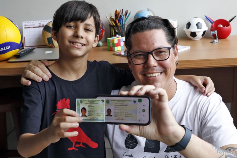 Bruno Peres/Agência Brasil Brasília (DF), 10/02/2025 - Samuel Veiga Mendes e o seu pai Leonardo Mendes mostrram Nova Carteira de Identidade Nacional. Foto: Bruno Peres/Agência Brasil